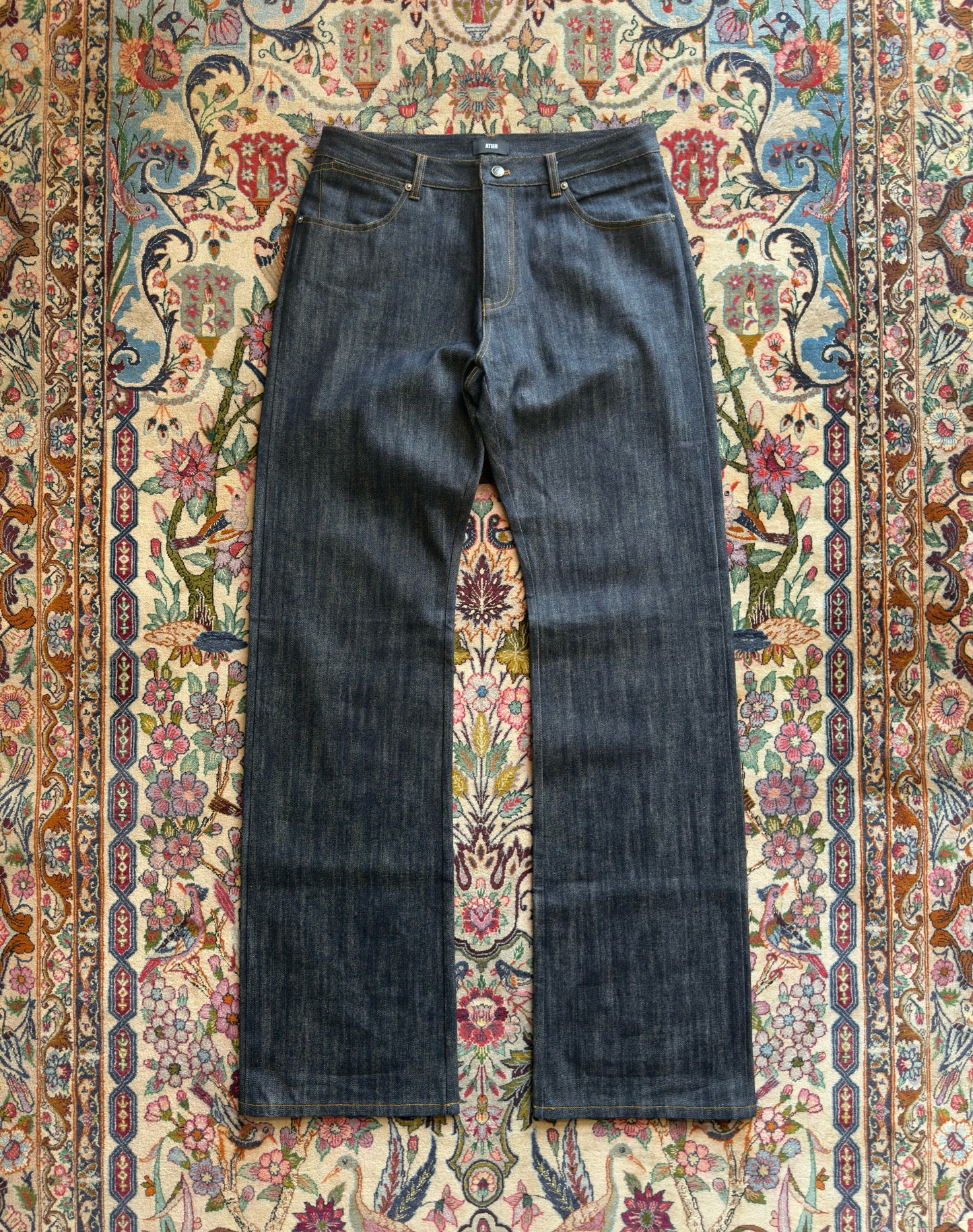 Jeans “Fusion Bootcut” in raw denim originale cimosato, ricamo e bottoni e rivetti in ottone logati