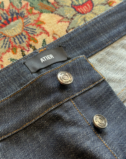 Jeans “Fusion Bootcut” in raw denim originale cimosato, ricamo e bottoni e rivetti in ottone logati