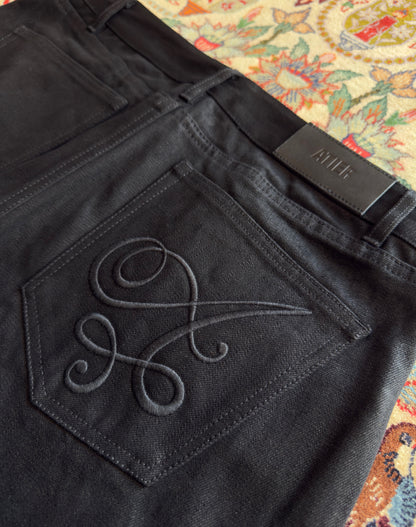 Jeans “Fusion Bootcut” in raw denim originale cimosato, ricamo e bottoni e rivetti in ottone logati