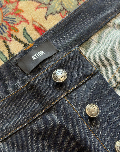 Jeans “Fusion Bootcut” in raw denim originale cimosato, ricamo e bottoni e rivetti in ottone logati